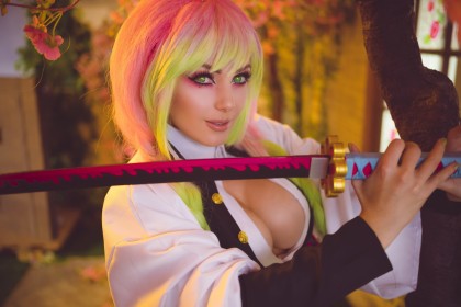 arme,caucasien,cheveux multicolores,cleavage,cosplay,demon slayer,épée,femme,frange,gros seins,jessica nigri,kanroji mitsuri,katana,sourire,uniforme,yeux vert