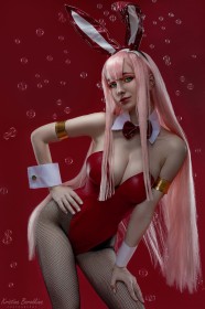 background rouge,bulle,caucasien,cheveux rose,cleavage,collant,collant en résille,cosplay,costume de lapin,darling in the franxx,fausses oreilles animaux,femme,frange,gros seins,hologana,leotard,main sur la hanche,résille,rouge a lèvres,yeux vert,zero two