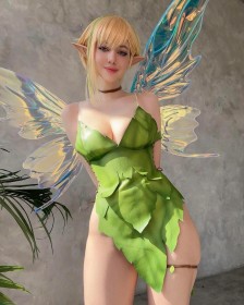 ailes,alina becker,bras dans le dos,caucasien,cheveux blond,cheveux multicolores,cleavage,cosplay,debout,fée,fée clochette,femme,frange,gros seins,grosses cuisses,hanches larges,non-nude,oreilles pointues,peter pan,robe,sangle de cuisse,sourire