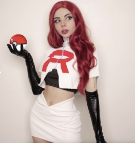 amanda welp,caucasien,cheveux rouge,cosplay,debout,femme,gants,gants de coude,haut court,jessie (pokemon),jupe,non-nude,pokemon,rouge a lèvres,yeux bleu