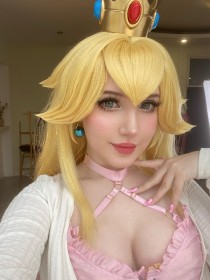 caucasien,cheveux blond,cleavage,cosplay,couronne,femme,mario (series),mèche entre les yeux,nintendo,ongles longs,princesse,princesse peach,rouge a lèvres,sourire,ulichan,vernis mains,yeux bleu